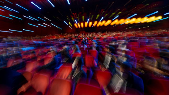 Zuschauer sitzen der Eröffnungsveranstaltung im Kinosaal. (Quelle: dpa/Monika Skolimowska)