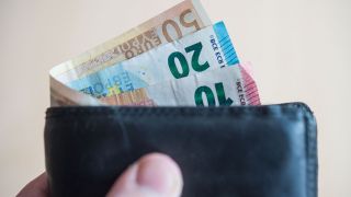 Geldscheine im Wert von fünf, zehn, zwanzig, fünfzig und hundert Euro stecken in einem Geldbeutel. (Quelle: dpa/Lino Mirgeler)