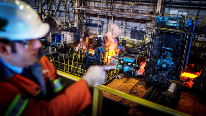 Archivbild: Ein Mitarbeiter der ArcelorMittal Eisenhuettenstadt GmbH steht im Warmwalzwerk und schaut auf die Fertigungsstrasse fuer Flachstahl. (Quelle: dpa/T. Trutschel)