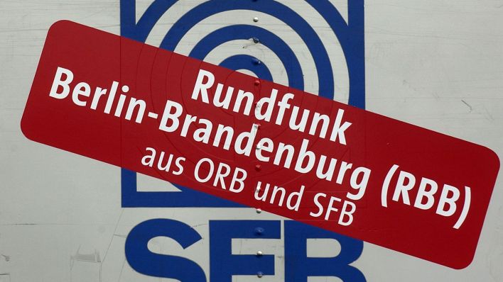Das auf einem Sendewagen abgebildete Logo des Senders Freies Berlin (SFB) ist mit dem Aufkleber Rundfunk Berlin-Brandenburg (RBB) überklebt. (Quelle: dpa/Andreas Altwein)