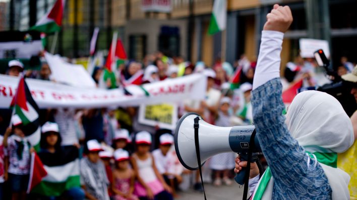 Archivbild: Eine Frau spricht in Berlin während einer pro-palästinensischen Demonstration auf dem Potsdamer Platz in ein Megafon. Der Gaza-Konflikt schürt Emotionen auch in Berlin zwischen Israelis und Palästinensern. (Quelle: dpa/D. Bockwoldt)