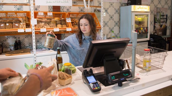 Symbolbild: Eine Verkäuferin scannt in einem Lebensmittelgeschäft Produkte an der Kasse ein. (Quelle: dpa/I. Kjer)