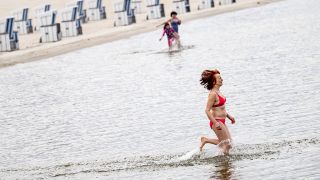 Eine Frau läuft beim traditionellen Anbaden im Strandbad Wannsee am Karfreitag ins 8,4 Grad kalte Wasser. (Quelle: dpa/Fabian Sommer)