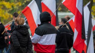 Symbolbild:Rechtsextreme Demonstrierende laufen bei einer Kundgebung mit Reichsflaggen mit.(Quelle:imago images/E.Thonfeld)