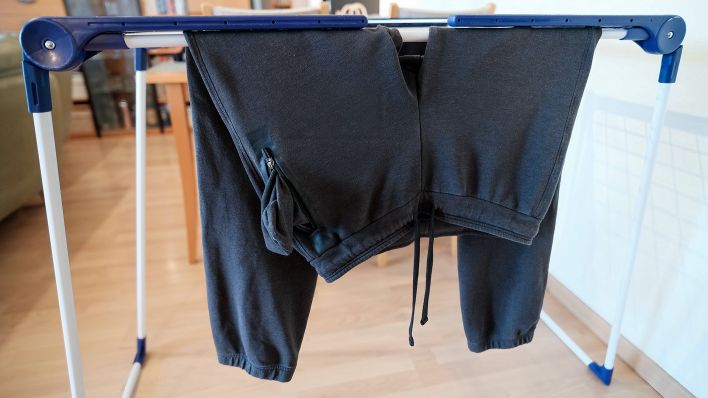 Symbolbild: Eine Jogging-Hose trocknet auf einem Kleiderständer. (Quelle: imago images/M. Gstettenbauer)