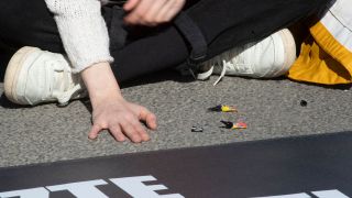 Ein Mitglied der Gruppe "Letzte Generation" hat sich im Rahmen einer Protestaktionen gegen die Klimapolitik auf einer Straße festgeklebt. (Quelle: imago-images/Olaf Wagner)