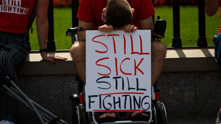 Auch in den USA haben Menschen für eine entschlossenere Hilfe der Politik im Kampf gegen Long-Covid und ME/CFS demonstriert. Ein Demonstrant hält ein Schild mit der Aufschrift "Still Sick, Still Fighting". (Quelle: dpa/Bryan Olin Dozier)