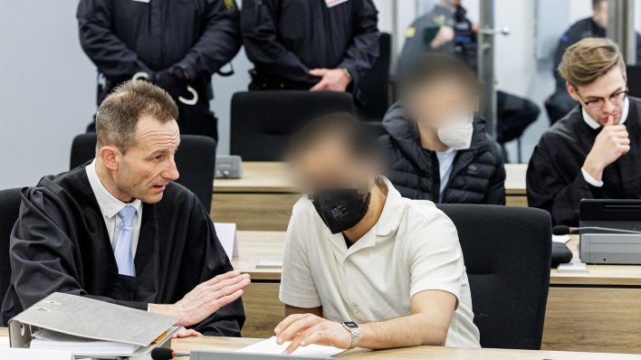 Angeklagter Mohamed R. (vordere Reihe r) und Angeklagter Bashir R. (2. Reihe, 2. r) sitzen am 20.03.2023 neben ihren Anwälten im Gerichtssaal des Oberlandesgerichts Dresden. (Quelle: AFP-Pool/Jens Schlueter)