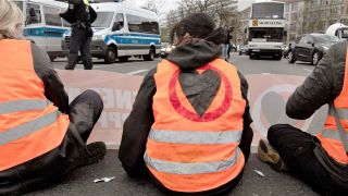 Aktivisten der Umweltschutz-Gruppe Letzte Generation sitzen bei einer Blockade am Ernst-Reuter-Platz auf der Straße. Erneut blockierten Aktivisten stadtweit zahlreiche Straßen. Bis zu 800 Unterstützer sollten an Aktionen und Blockaden teilnehmen. (Foto: dpa)