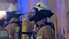 Symbolbild: Ein Feuerwehrmann mit einer Atemschutzmaske steht während eines Dachstuhlbrandes am 19.02.2018 in der Berliner Richardstraße. (Quelle: Picture Alliance / Paul Zinken)