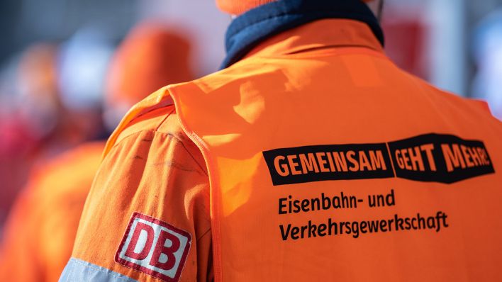Symbolbild:Ein Bahnmitarbeiter in einer Weste der Eisenbahn- und Verkehrsgewerkschaft (EVG).(Quelle:dpa/H.Schmidt)