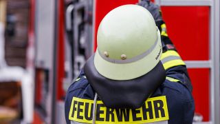 Symbolbild:Ein Feuerwehrmann holt eine Leiter vom Dach eines Einsatzfahrzeugs.(Quelle:dpa/P.v.Ditfurth)