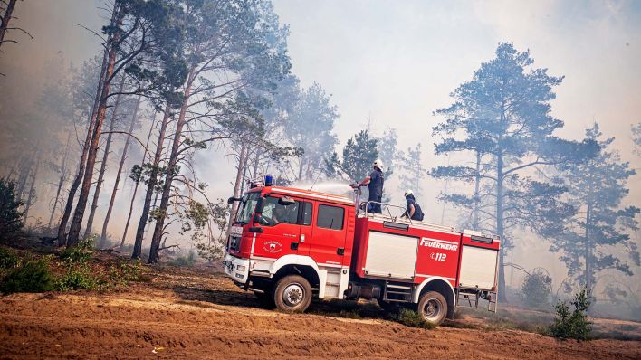 Einsatzkräfte der Feuerwehr bekämpfen am 05.06.2023 in einem Waldstück nahe Jüterbog das Feuer.(Quelle:dpa/F.Sommer)