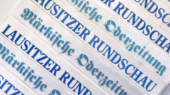 Exemplare der Tageszeitung "Lausitzer Rundschau" und der "Märkischen Oderzeitung" liegen symbolhaft auf einem Tisch. (Quelle: dpa/Ralf Hirschberger)