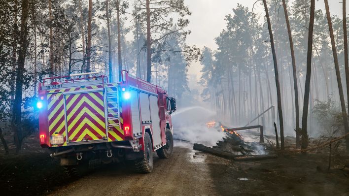 Symbolbild: Feuerwehrleute löschen einen Waldbrand. (Quelle: dpa/Jan Woitas)