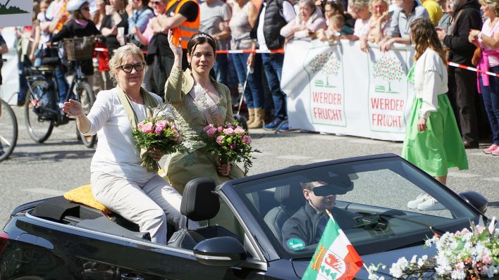 Werders Bürgermeisterin Manuela Saß (l) sitzt zusammen mit der neuen Baumblütenkönigin Doreen Vogler beim Festumzug des Baumblütenfestes Werder in einem Auto. (Quelle: dpa/Michael Bahlo)