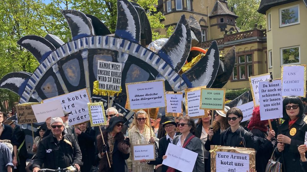 Teilnehmer der linken Demonstration "MyGruni" stehen mit Plakaten im Villenviertel Berlin-Grunewald. (Quelle: dpa/Lukas Dubro)