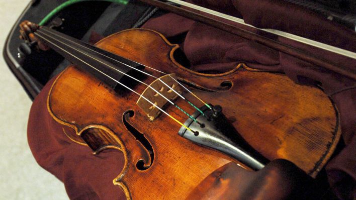 Symbolbild: Eine Geige liegt in einem gepolsterten Geigenkoffer. (Quelle: dpa/D. Lewis)