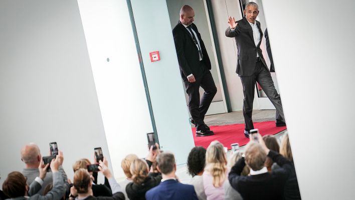 Der frühere US-Präsidenten Barack Obama (r) winkt im Bundeskanzleramt den Mitarbeitern des Kanzleramtes bei der Ankunft zu. (Quelle: dpa/K. Nietfeld)