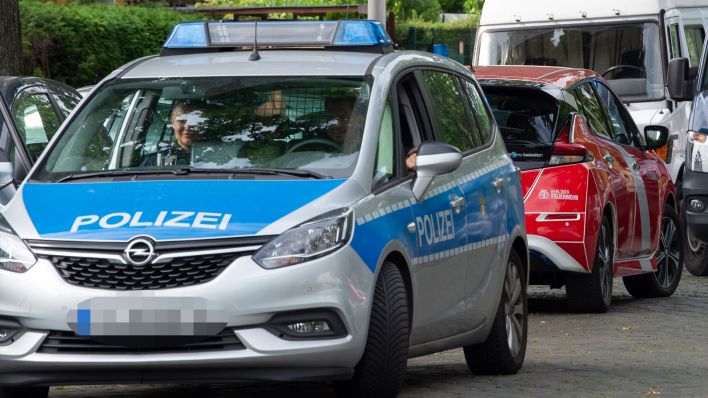Symbolbild: Ein Polizeiwagen steht bei einem Einsatz in zweiter Spur auf der Straße. (Quelle: dpa/P. Zinken)