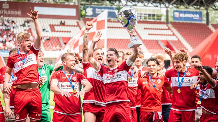 Die Spieler von Energie Cottbus feiern die Regionalliga-Meisterschaft (Bild: IMAGO/Matthias Koch)