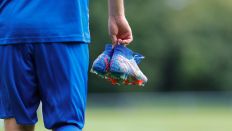 Fußball-Spieler mit einem Paar Schuhe in der Hand (Quelle: IMAGO / Marcel Lorenz)