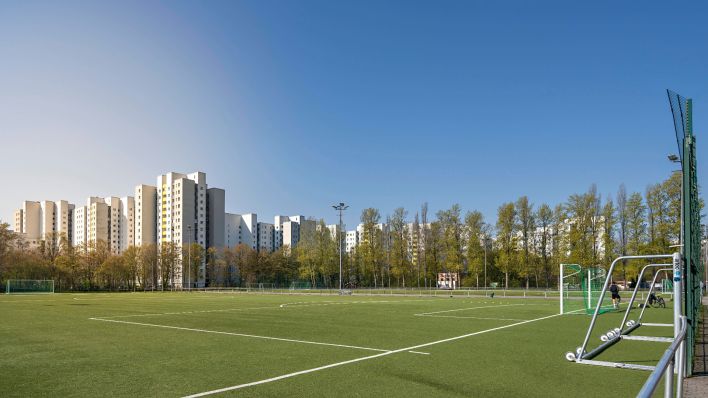 Fußballfeld und Hochhäuser im Wohngebiet Märkisches Viertel (Bild: IMAGO/Imagebroker)