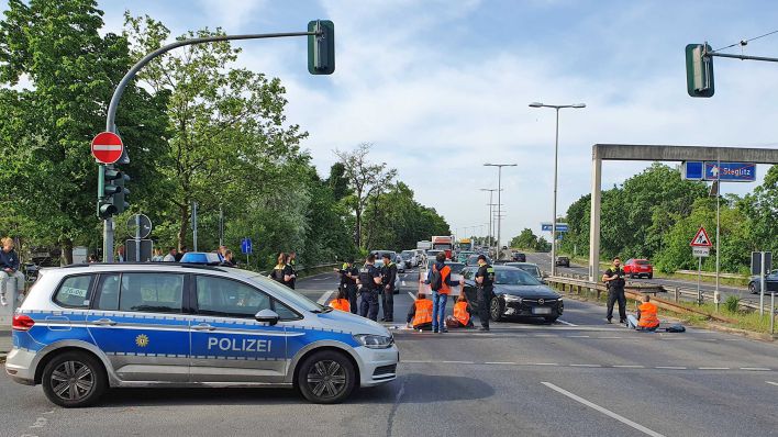 Aktivisten der Gruppe "Letzte Generation" bei einer Blockade-Aktion am 22.05.2023 an der Autobahnabfahrt Konstanzer Str/ Ecke Berliner Str. in Berlin. (Quelle: rbb24/Stefan Oberwalleney)