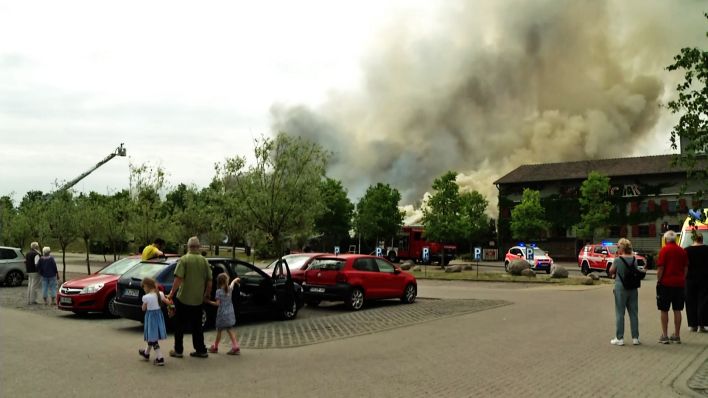 Menschen beobachten die Rauchwolke beim Brand bei Karl´s Hof.(Quelle:rbb)