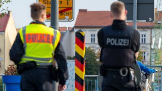 Symbolbild: Zwei Polizisten kontrollieren den Verkehr auf der Grenzbrücke zwischen Deutschland und Polen (Quelle: dpa/Monika Skolimowska)