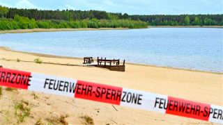Archiv: Mit einem Flatterband ist ein Zugang zum Strand des Helenesees abgesperrt. (Foto:dpa)