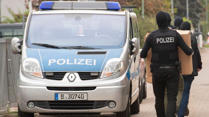 Symbolbild: Polizeibeamte tragen am 29.09.2022 Kisten nach einer Razzia in einem Berliner Vereinsheim. (Quelle: dpa/Paul Zinken)