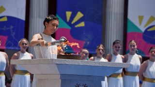 Eine Schauspielerin zündet die Special Olympics Fackel am 7.Juni 2023 in Athen, Griechenland an. (Quelle: dpa/ZUMA Press Wire/Nikolas Georgiou)