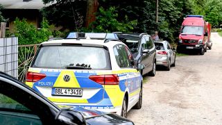 Polizeifahrzeuge stehen im Ortsteil Deutsch Wusterhausen in Königs Wusterhausen im Landkreis Dahme-Spreewald vor einem Grundstück.(Foto: dpa)