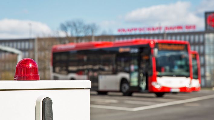 Symbolbild:Eine rote Warnleuchte, dahinter Busse der Firma Cottbusverkehr.(Quelle:dpa/Fotostand)