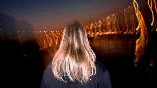 Symbolbild:Blonde Frau von hinten bei Nacht mit Licht.(Quelle:picture alliance/CHROMORANGE/Florian Schumacher)