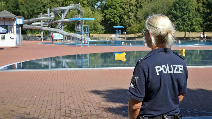 Symbolbild:Eine Polizeibeamtin beobachtet im Sommerbad Pankow das Badegeschehen.(Quelle:dpa/W.Kumm)