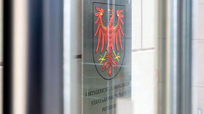 Das Metallschild neben dem Eingang zum Justizzentrum mit dem Roten Adler als Landeswappen und dem Verweis auf Amtsgericht, Landgericht und Staatsanwaltschaft. (Quelle: dpa/Soeren Stache)