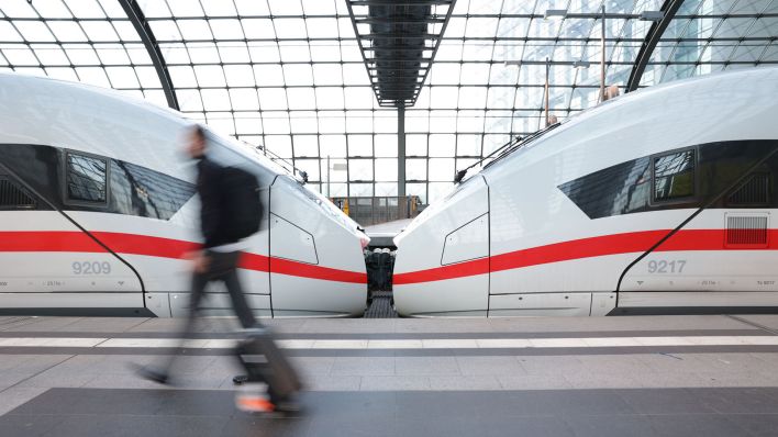 Reisende eilen am frühen Morgen zu einem ICE am Hauptbahnhof. (Quelle: dpa/Jörg Carstensen)
