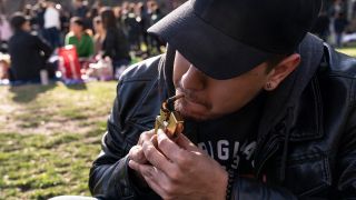 Symbolbild: Ein Jugendlicher konsumiert in einem Park Marijuana. (Quelle: imago images/L. Radin)