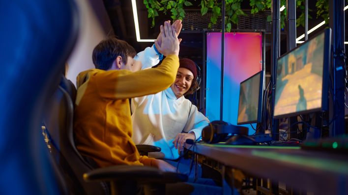 Symbolbild: Zwei Gamer schlagen nach einem gelungenen Spiel ein. (Quelle: dpa/panthermedia)