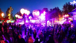 Symbolbild: Festivalbesucher tanzen auf einer mit leuchtenden Ballonen geschmückten Bühne auf dem Gelände des Fusion-Festival. (Quelle: dpa/C. Charisius)