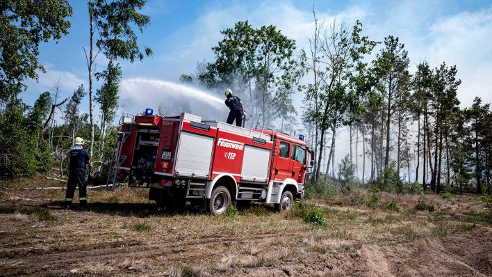 Archivbild: Einsatzkräfte der Feuerwehr bekämpfen in einem Waldstück nahe Jüterbog das Feuer. (Quelle: dpa/F. Sommer)