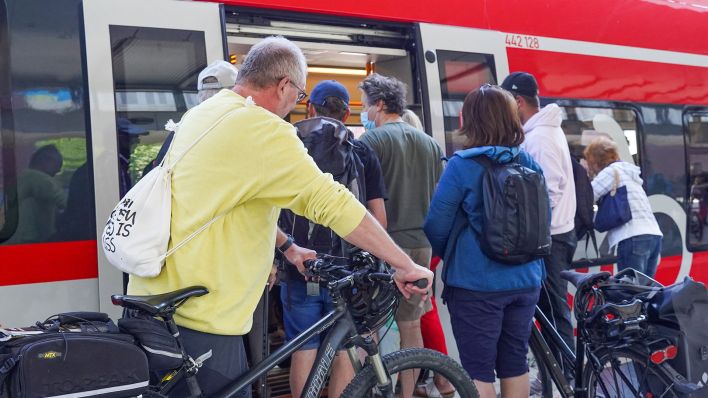 Zuggäste, teilweise mit Fahrrad, steigen am Bahnhof Gesundbrunnen in einen Regionalzug. (Quelle: dpa/Jörg Carstensen)