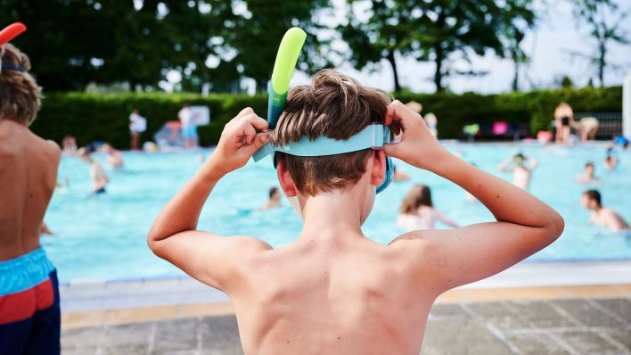 Symbolbild:Ein Kind setzt sich seine Taucherbrille im Sommerbad Olympiastadion auf.(Quelle:dpa/A.Riedl)