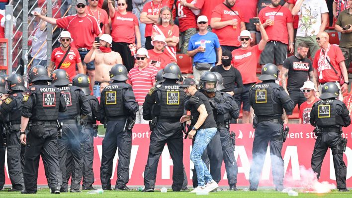 Polizei vor dem Cottbuser Block, Trainer Claus-Dieter Wollitz versucht zu beruhigen. / imago images/Matthias Koch