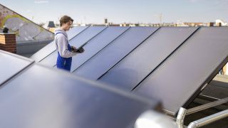 Ein Gebäudetechniker kontrolliert am 06.04.2023 eine Solaranlage in Berlin. (Quelle: Imago Images/Sebastian Rau)