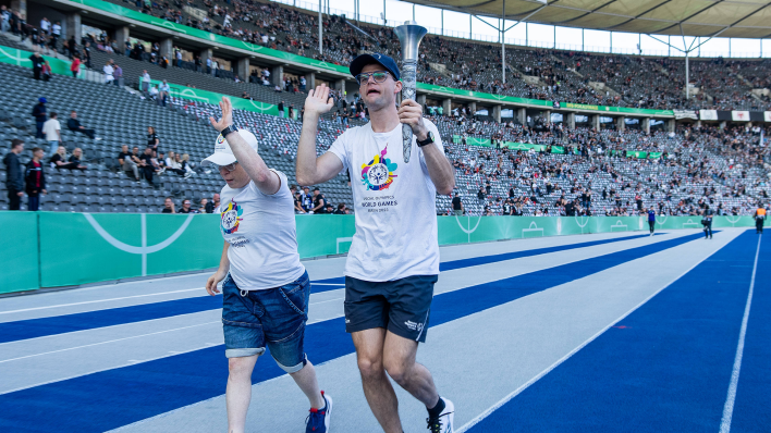 Der Berliner Mittelstreckenläufer Jann Rathenow trägt die olympische Fackel durch das Olympiastadion. (Foto: IMAGO / Schüler)