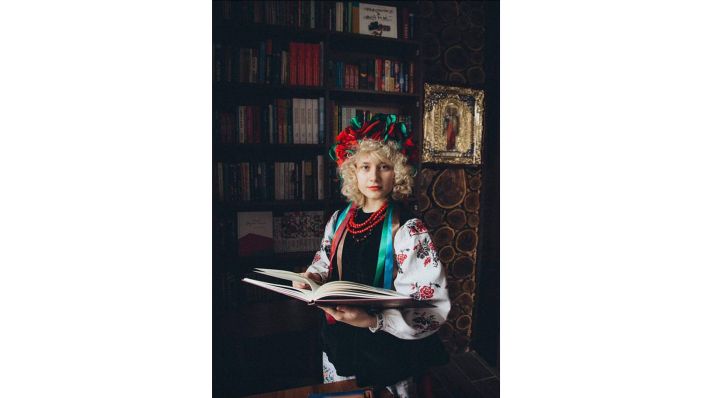 Maria vor einem Bücherregal mit einem Buch in der Hand.(Quelle:privat)