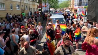 Menschen laufen mit Regenbogenfahnen durch Wittenberge (Prignitz). (Bild: rbb)